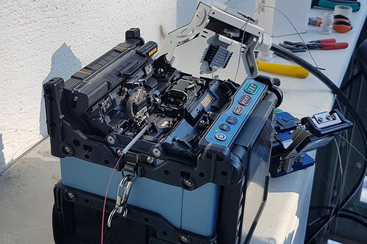 Field workbench with fusion splicer and fiber preparation tools during plant certification